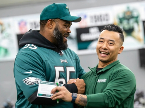 An Eagles football player laughing with a NovaCare physical therapist.