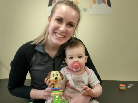 Physical therapist Courtney Davis holding baby Amalia in her lap in a SSM physical therapy center.